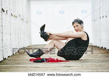 Older Caucasian woman taking off boots on wooden dock View Large Photo Image Stock Photo - Older Caucasian woman taking off boots on wooden dock. Fotosearch