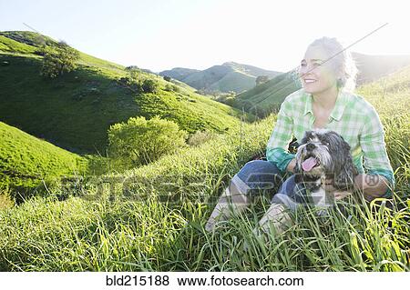 Older Caucasian woman walking dog on grassy hillside View Large Photo Image Stock Photo - Older Caucasian woman walking dog on grassy hillside. Fotosearch