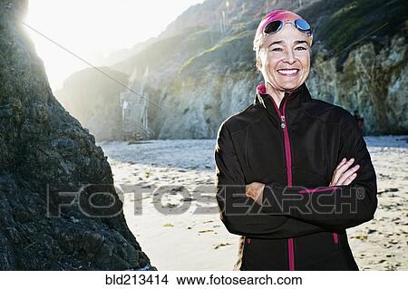 Picture - Older Caucasian woman wearing goggles on beach. Fotosearch