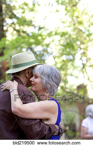 Stock Image - Older couple dancing in backyard. Fotosearch