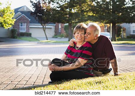 Older Hispanic couple kissing outside suburban home View Large Photo Image Stock Photo - Older Hispanic couple kissing outside suburban home. Fotosearch