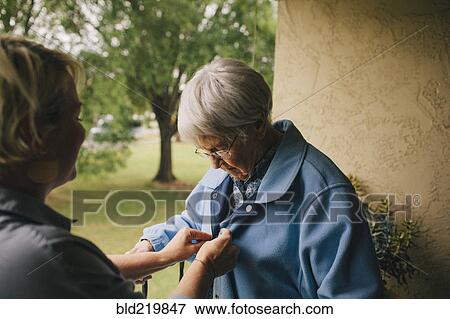 Stock Photo - Older woman and granddaughter standing on balcony. Fotosearch