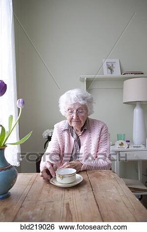 Older woman drinking tea at table View Large Photo Image Stock Photograph - Older woman drinking tea at table. Fotosearch