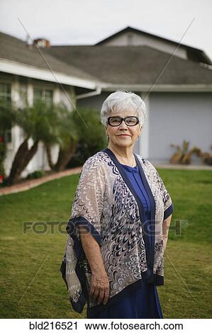 Older woman standing in backyard View Large Photo Image Stock Image - Older woman standing in backyard. Fotosearch