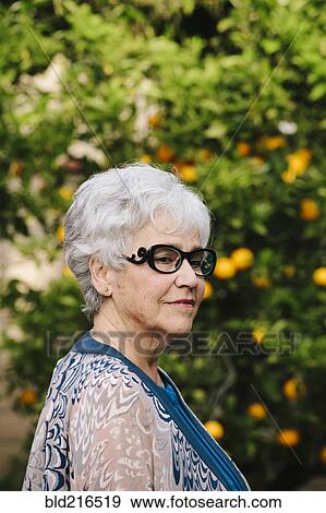 Stock Photo - Older woman standing outdoors. Fotosearch