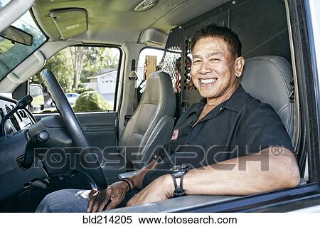 Stock Photography - Pacific Islander plumber smiling in van. Fotosearch