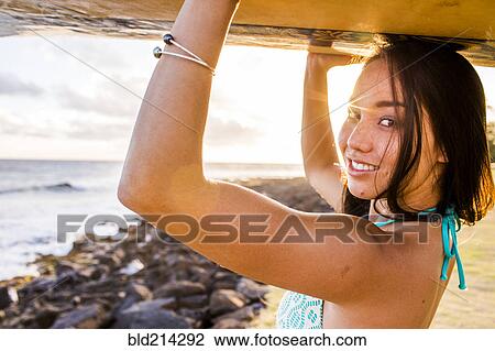 Pacific Islander surfer carrying surfboard on rocky beach View Large Photo Image Stock Image - Pacific Islander surfer carrying surfboard on rocky beach. Fotosearch