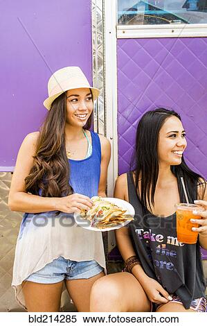 Pacific Islander women eating and drinking near food cart View Large Photo Image Stock Photography - Pacific Islander women eating and drinking near food cart. Fotosearch