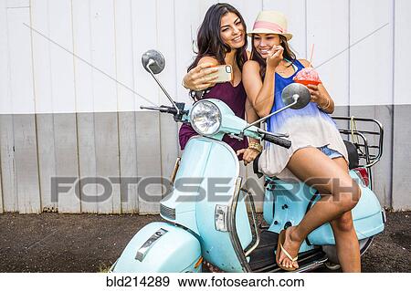 Pacific Islander women taking cell phone photograph on scooter View Large Photo Image Stock Photo - Pacific Islander women taking cell phone photograph on scooter. Fotosearch