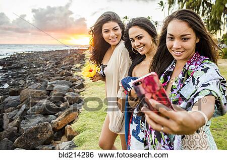 Pacific Islander women taking cell phone photograph near rocky beach View Large Photo Image Stock Photograph - Pacific Islander women taking cell phone photograph near rocky beach. Fotosearch