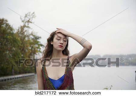 Pensive woman standing near lake View Large Photo Image Stock Image - Pensive woman standing near lake. Fotosearch