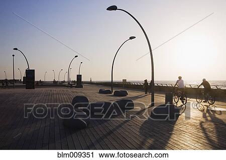 People riding bicycles on boardwalk near ocean View Large Photo Image Stock Image - People riding bicycles on boardwalk near ocean. Fotosearch