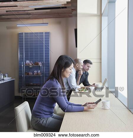 Picture - People using electronics in cafe. Fotosearch