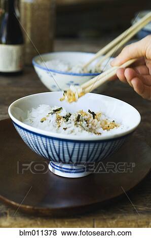 Person eating rice with chopsticks View Large Photo Image Stock Photo - Person eating rice with chopsticks. Fotosearch
