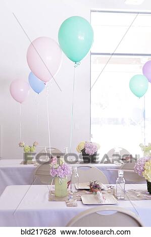 Stock Photo - Place settings on party tables under balloons. Fotosearch