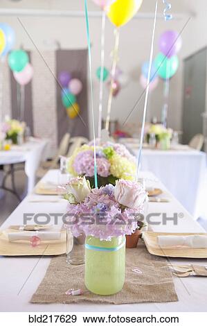 Stock Photo - Place settings on party tables under balloons. Fotosearch