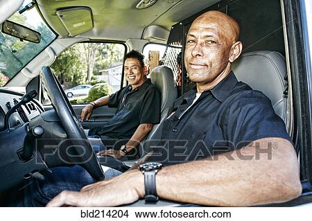 Picture - Plumbers smiling in van. Fotosearch