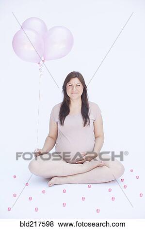 Pregnant Caucasian woman holding bunch of balloons View Large Photo Image Stock Photo - Pregnant Caucasian woman holding bunch of balloons. Fotosearch