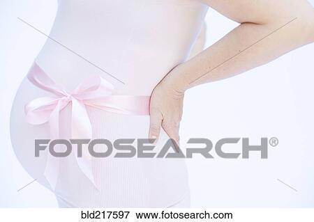 Stock Photo - Pregnant Caucasian woman with pink ribbon around belly. Fotosearch