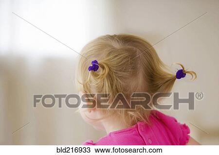 Stock Image - Rear view of baby girl with pigtails. Fotosearch