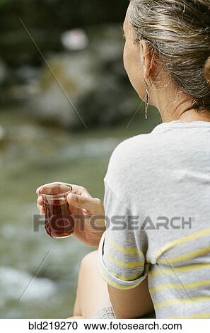Rear view of woman drinking cocktail outdoors View Large Photo Image Stock Image - Rear view of woman drinking cocktail outdoors. Fotosearch