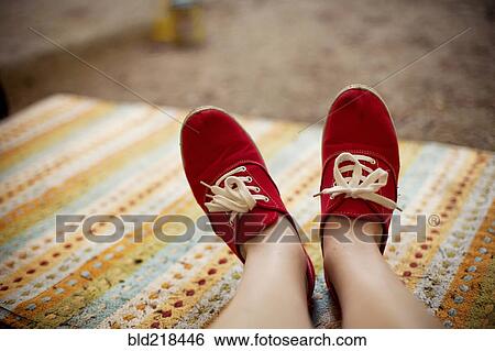 Red sneakers of Caucasian on rug View Large Photo Image Stock Photograph - Red sneakers of Caucasian on rug. Fotosearch