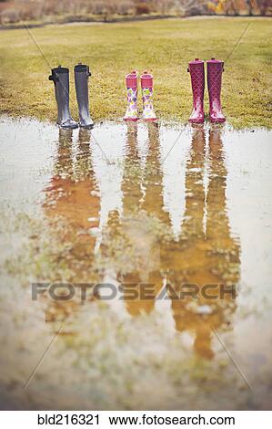Reflection of people from rain boots in puddle View Large Photo Image Stock Image - Reflection of people from rain boots in puddle. Fotosearch