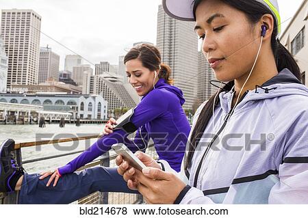 Runner using cell phone at waterfront, San Francisco, California, United States View Large Photo Image Stock Photo - Runner using cell phone at waterfront, San Francisco, California, United States. Fotosearch
