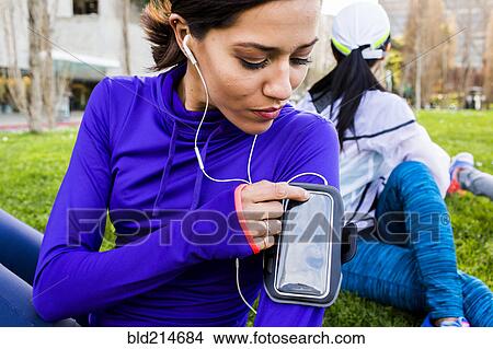 Picture - Runner using cell phone in urban park. Fotosearch
