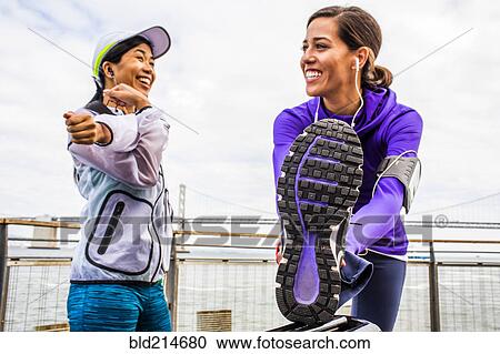 Stock Image - Runners stretching at waterfront, San Francisco, California, United States. Fotosearch