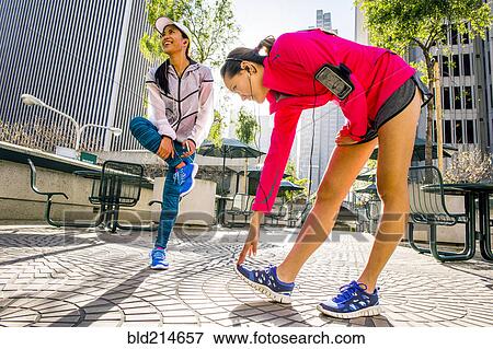 Stock Photo - Runners stretching in urban park. Fotosearch