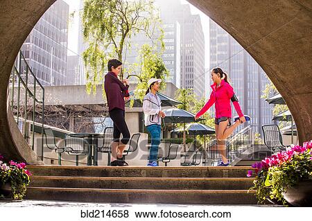 Stock Photo - Runners stretching in urban park. Fotosearch