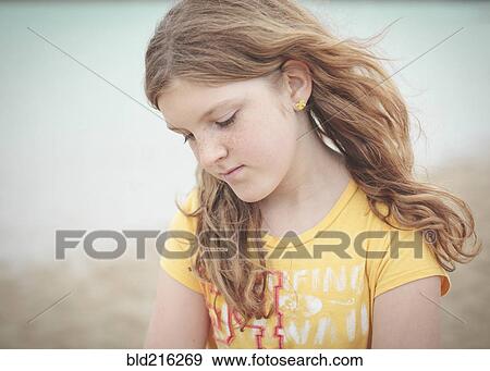 Stock Photo - Sad Caucasian girl looking down. Fotosearch