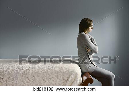 Sad Caucasian woman sitting on bed frame View Large Photo Image Stock Image - Sad Caucasian woman sitting on bed frame. Fotosearch