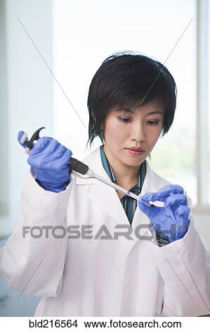 Scientist pipetting liquid into test tube in laboratory View Large Photo Image Picture - Scientist pipetting liquid into test tube in laboratory. Fotosearch