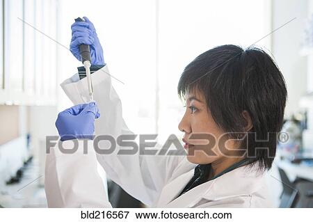 Scientist pipetting liquid into test tube in laboratory View Large Photo Image Stock Photo - Scientist pipetting liquid into test tube in laboratory. Fotosearch