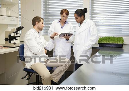 Stock Image - Scientists using digital tablet in laboratory. Fotosearch