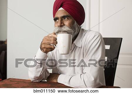 Stock Image - Senior Asian man drinking coffee. Fotosearch
