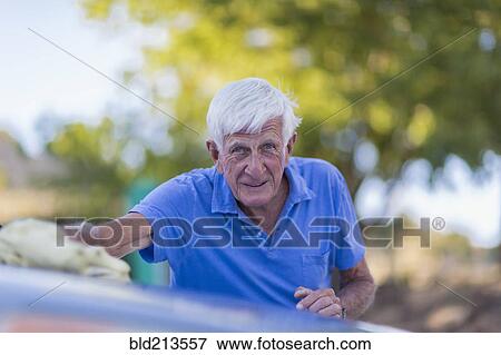 Stock Photo - Senior Caucasian man washing car outdoors. Fotosearch