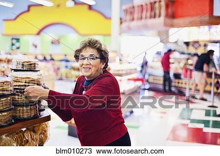 Senior Hispanic woman shopping in grocery store View Large Photo Image Stock Image - Senior Hispanic woman shopping in grocery store. Fotosearch