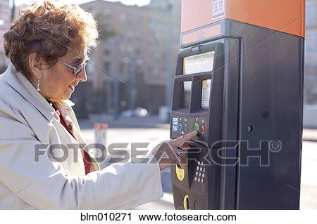 Senior Hispanic woman using parking meter View Large Photo Image Stock Image - Senior Hispanic woman using parking meter. Fotosearch