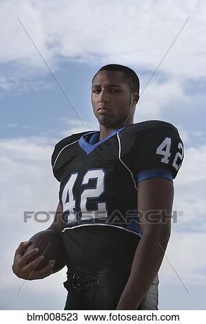 Serious African American football player holding football View Large Photo Image Stock Image - Serious African American football player holding football. Fotosearch