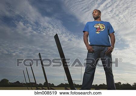 Serious African American man standing on football field View Large Photo Image Stock Photo - Serious African American man standing on football field. Fotosearch