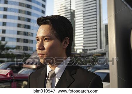 Stock Photo - Serious Asian businessman outdoors. Fotosearch