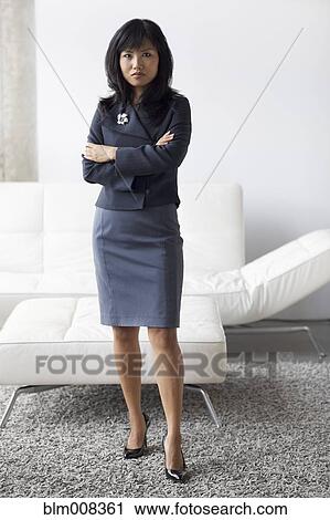 Stock Image - Serious Asian businesswoman with arms crossed. Fotosearch