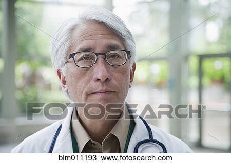 Stock Image - Serious Asian doctor. Fotosearch