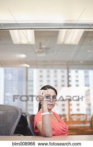 Stock Photograph - Serious Black businesswoman sitting in conference room. Fotosearch