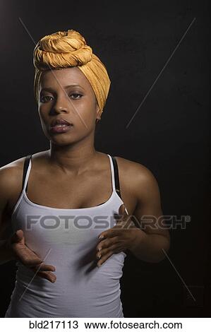 Stock Image - Serious Black woman wearing headwrap. Fotosearch