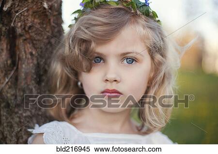 Stock Photography - Serious Caucasian girl near tree. Fotosearch