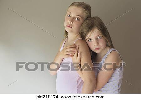 Picture - Serious Caucasian girls hugging. Fotosearch